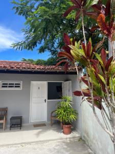 uma casa com uma porta branca e algumas plantas em Pousada El Camenito Geribá Búzios em Búzios