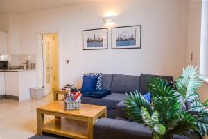 uma sala de estar com um sofá azul e uma mesa em Cozy Entire Flat with Gated Parking- Contractors, Family, Groups em Reading