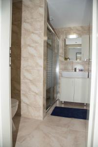 Townhouse 23, Lagada Resort في ماكري جيالوس: حمام مع دش ومغسلة ومرحاض