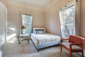 a bedroom with a bed and a chair and windows at Eclectic Sacramento Home about Half Mi to Downtown! in Sacramento