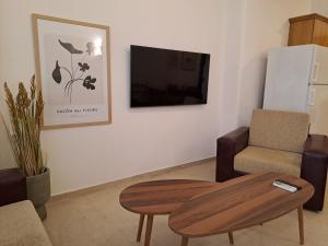 a living room with a table and a tv at CENTER o'CLOCK in Xanthi