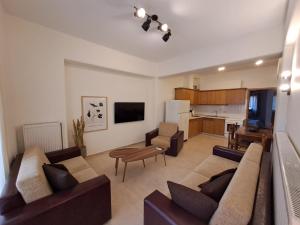 sala de estar con 2 sofás y cocina en CENTER o'CLOCK, en Xanthi