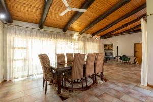 uma sala de jantar com mesa e cadeiras em The Pal Guest House em Gaborone