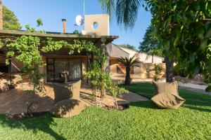 un patio con almohadas en el césped en The Pal Guest House, en Gaborone
