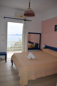 1 dormitorio con 1 cama y ventana grande en Paradisus Apartments en Barbati
