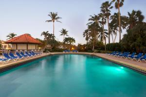 einen Pool mit Stühlen und Palmen in der Unterkunft Lexington by Hotel RL Miami Beach in Miami Beach