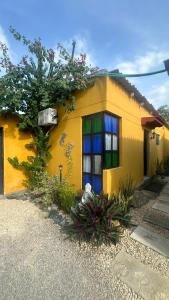 una casa amarilla con ventanas y plantas coloridas en Los Kioscos Coveñas-Tolu, en Coveñas