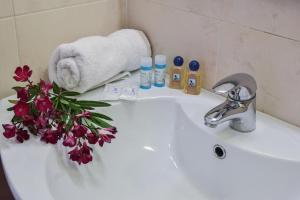 
a white towel sitting on top of a white sink at Keri Village & Spa by Zante Plaza (Adults Only) in Keri
