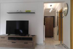 a living room with a flat screen tv on a wooden entertainment center at 100sqm comfort free parking Airport 10min in Thessaloniki