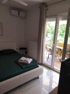 a bedroom with a bed and a door to a patio at 100sqm comfort free parking Airport 10min in Thessaloniki