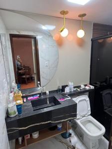a bathroom with a sink and a toilet and a mirror at FLAT NA PRAIA DO MEIO in São-José-do-Ribamar