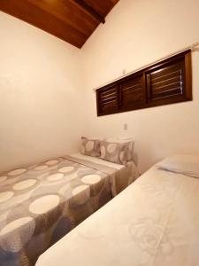 a bedroom with two beds and a window at Casa Vida Li in Ilha de Boipeba