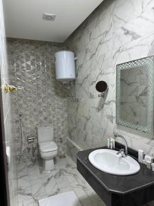 a bathroom with a sink and a toilet and a mirror at Tuya Pyramids View in Cairo
