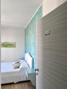 1 dormitorio con 1 cama y puerta de madera en Bella Tropea Accommodation en Tropea