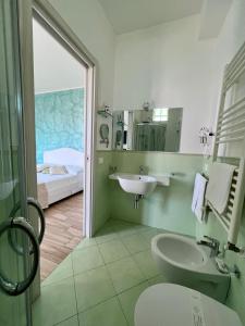 a bathroom with a sink and a toilet and a bed at Bella Tropea Accommodation in Tropea