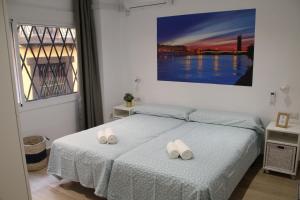 een slaapkamer met een bed met twee handdoeken erop bij LUISAHOUSE, en el corazón de Sevilla y Triana in Sevilla