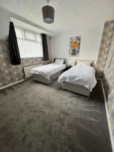 a bedroom with two beds and a window at West Midlands Contractors, Nurses and Families 