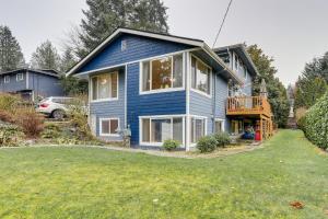 a blue house with a balcony and a yard at Redmond Retreat Steps to Lake and Idylwood Park! in Redmond
