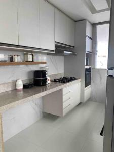 uma cozinha branca com armários e electrodomésticos brancos em Casa com 3 quartos e piscina - 8 min da Praia em São José de Ribamar