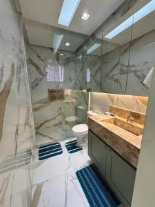 uma casa de banho em mármore com um WC e um lavatório. em Casa com 3 quartos e piscina - 8 min da Praia em São José de Ribamar