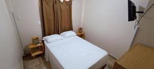 Un pequeño dormitorio con una cama blanca en una habitación en Tierra Mía, en Posadas