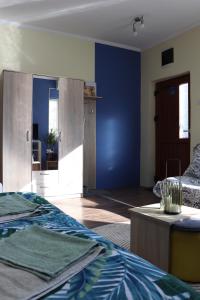 Habitación con cama y pared azul en Center Apartment Dunja, en Subotica