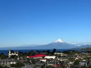 una città con una montagna innevata sullo sfondo di Hermoso depa a Puerto Varas