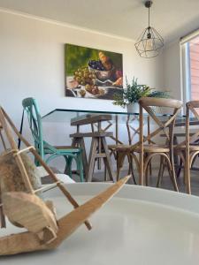 Hermoso depa في بورتو فاراس: غرفة طعام مع طاولة مع كراسي و لوحة