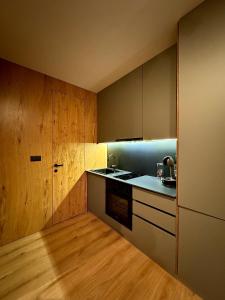 a kitchen with wooden cabinets and a sink and a stove at Grandpa's Chalet Jahorina in Jahorina