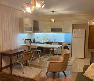 uma cozinha com uma mesa e cadeiras e um frigorífico em Cozy Apartment in a Popular Neighborhood em Çorlu