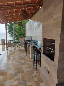 une cuisine avec une table et des chaises sur une terrasse dans l'établissement Casa à beira lago de Furnas. (Pé na água), à Formiga