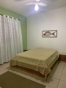 - une chambre avec un lit et un ventilateur de plafond dans l'établissement Casa à beira lago de Furnas. (Pé na água), à Formiga