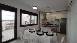 a dining room with a table and chairs and a kitchen at CASA RURAL ELENYR in Calera de León