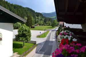 a street with flowers on the side of a building at Pension Haus Rohrmoser in Annaberg im Lammertal