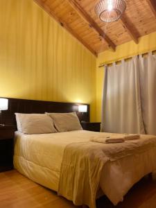 a bedroom with a large bed and a white curtain at Ruca Nel in El Calafate