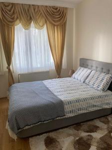- une chambre avec un lit et une fenêtre avec des rideaux dans l'établissement Cozy Apartment in a Popular Neighborhood, à Çorlu