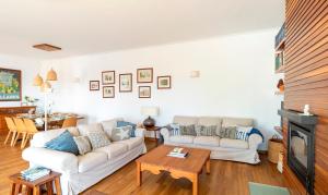 un soggiorno con un divano e un tavolo di Colares beach house, pool child friendly a Colares