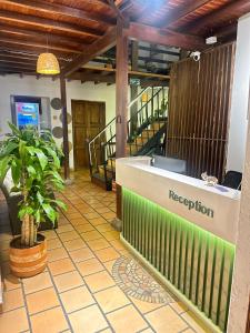 a lobby with a reception desk and a plant at THIS IS COLOMBIA HOSTEL in San Gil