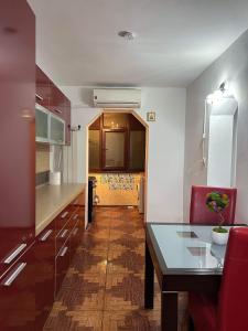 a kitchen with a glass table and a red chair at LukApartaments in Tulcea