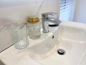 a sink with a faucet and a glass on it at Luxury 2 Bed Apartment in Portadown
