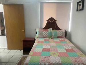 a bedroom with a bed with a quilt on it at Depa Los abuelos en Puerto Vallarta in Puerto Vallarta