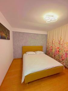 een slaapkamer met een bed en een schilderij aan de muur bij LukApartaments in Tulcea