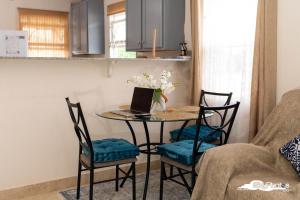 a kitchen with a table with a laptop on it at Serendipity in The Villages in Christ Church