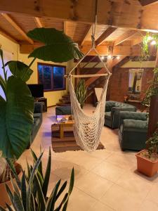 a living room with a hammock hanging from the ceiling at Ruca Nel in El Calafate