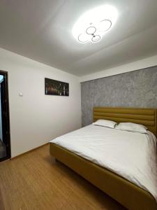 a bedroom with a bed with a light on the ceiling at LukApartaments in Tulcea
