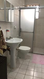 a bathroom with a sink and a toilet and a shower at Quarto em apartamento in Sao Paulo