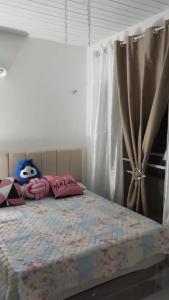 1 dormitorio con 1 cama con almohadas rosas en Casa duplex, en Caucaia