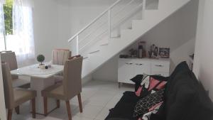une salle à manger blanche avec une table et un escalier dans l'établissement Casa duplex, à Caucaia