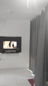 Habitación con TV y cortina. en Casa duplex, en Caucaia