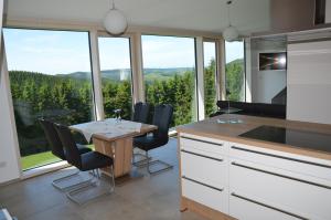 a kitchen with a table and chairs and a large window at Ferienhaus zur Glocke in Winterberg